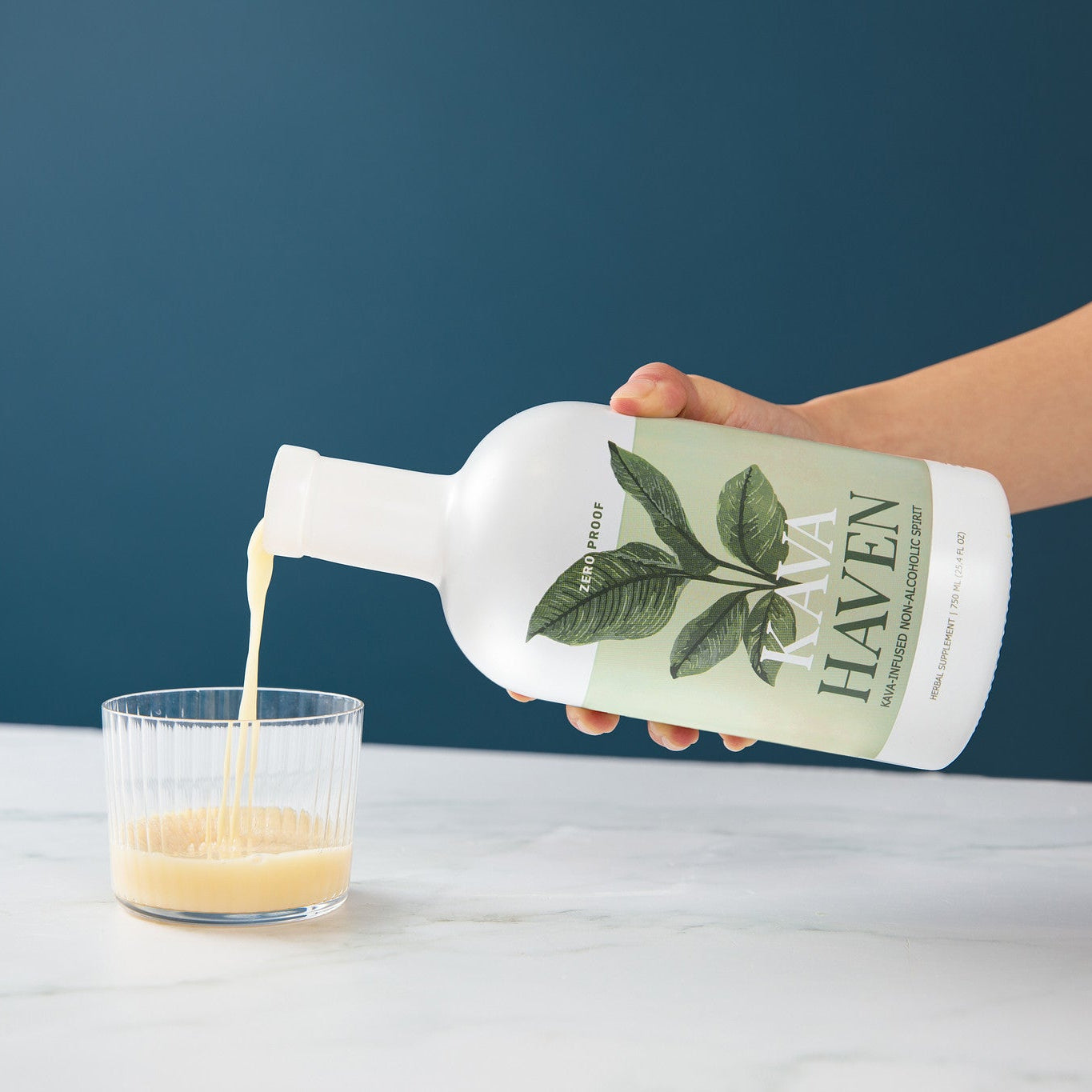 Pouring Kava Haven non-alcoholic spirit into a rocks glass